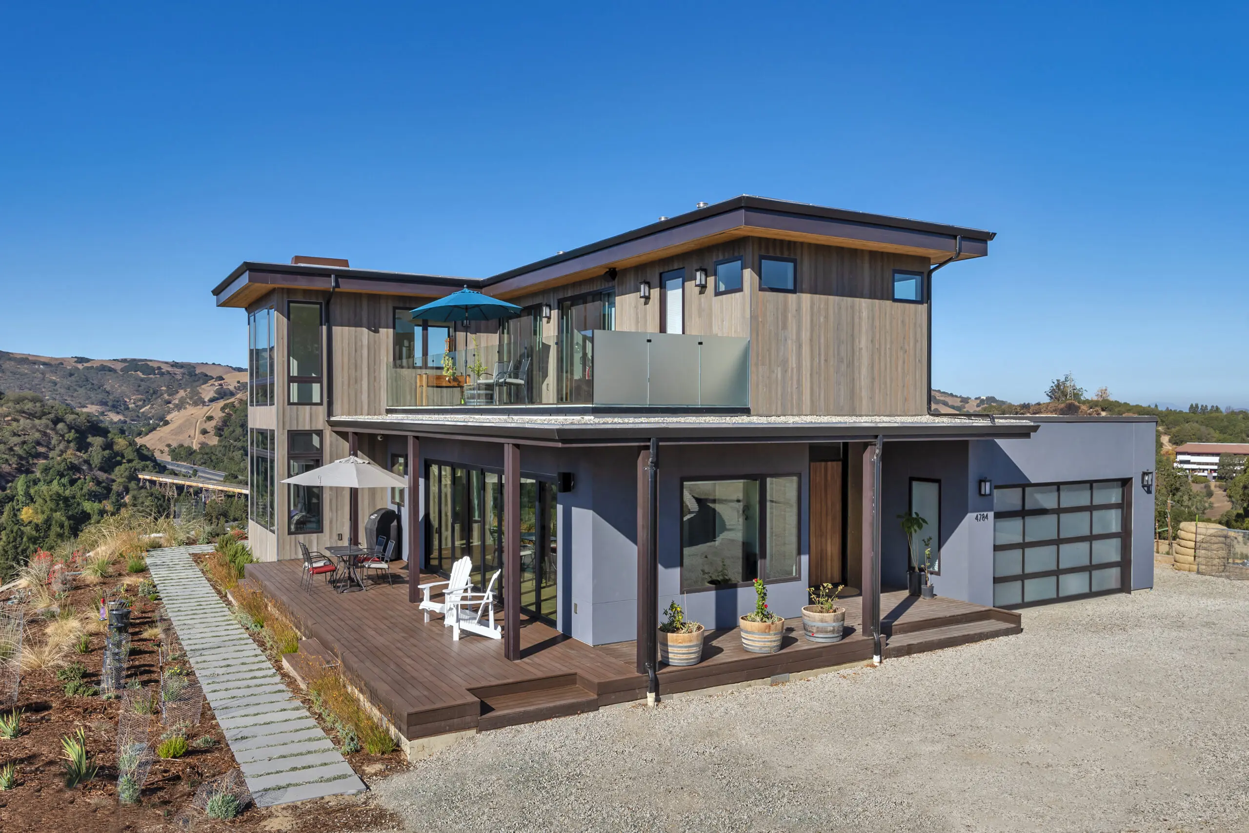 CleverHomes Modern style, two-story house in scrubland landscape.